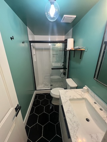 Completed bathroom remodel with tiled shower and custom vanity