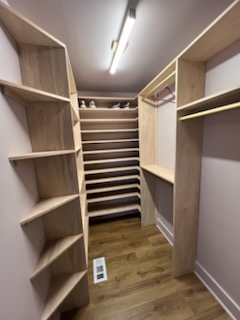 Custom walk-in closet with wood shelving and hanging space